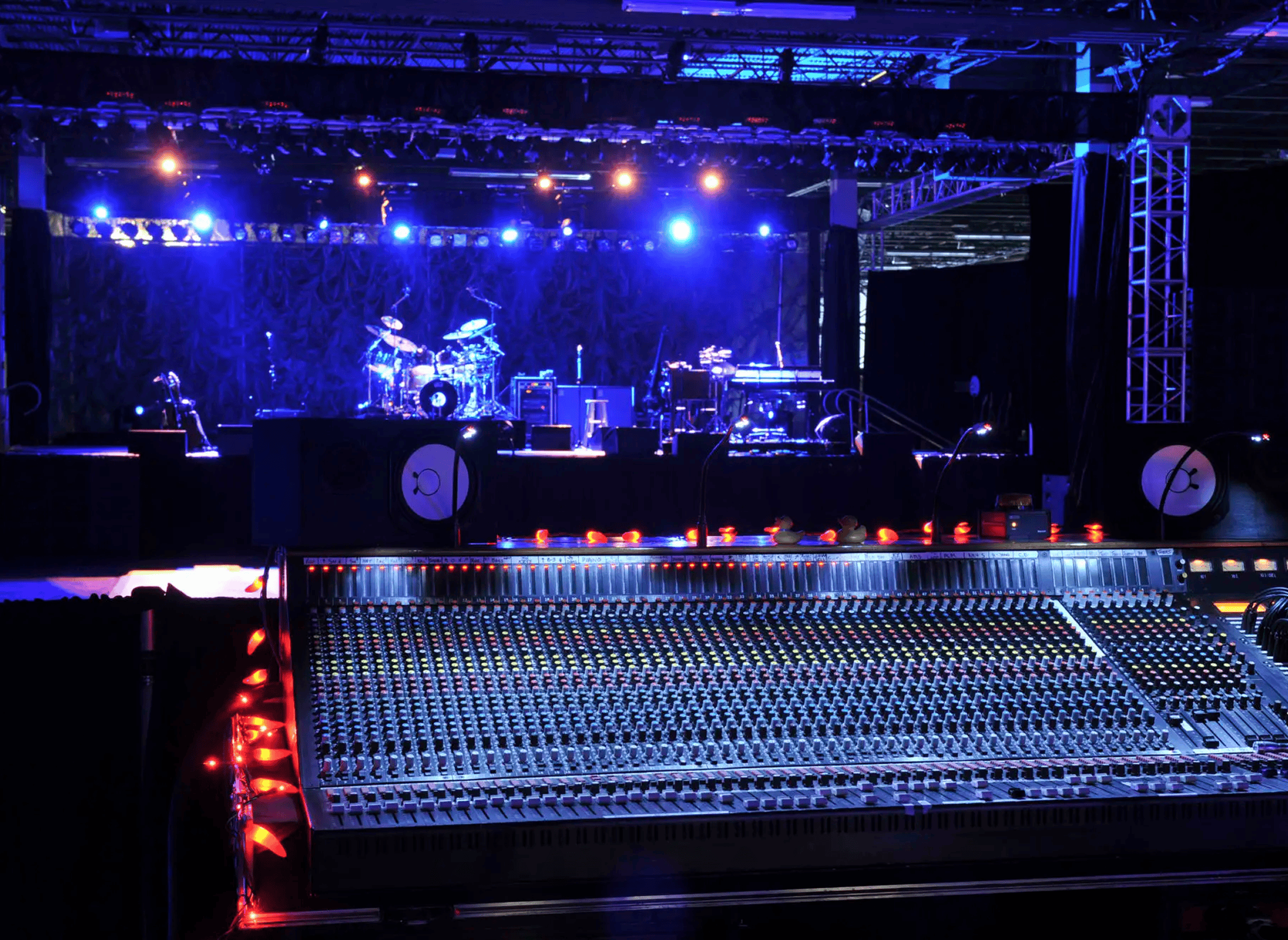 Mixing console in front of blue-lit stage